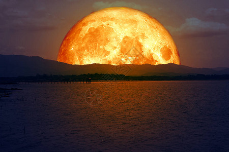 山上的血月和湖上的光反射图片