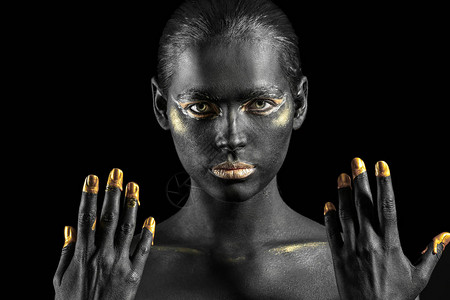 在黑暗背景下身上涂着黑金漆的漂亮女人图片