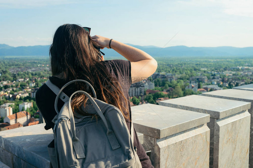 带着摄像头的女孩背包者拍摄了斯洛文尼亚卢布尔雅那市景的照片从图片