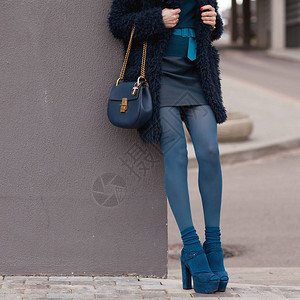 一个穿蓝色毛皮大衣的女孩穿着高跟鞋的手提包详情图片