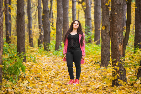秋天自然和人的概念在公园穿粉红色夹克图片