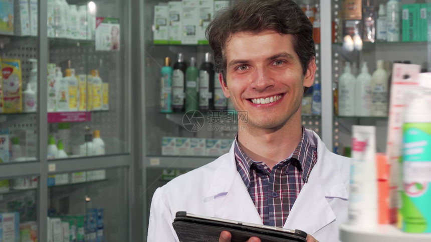 格开朗的专业药剂师在药房做库存时对着镜头微笑图片