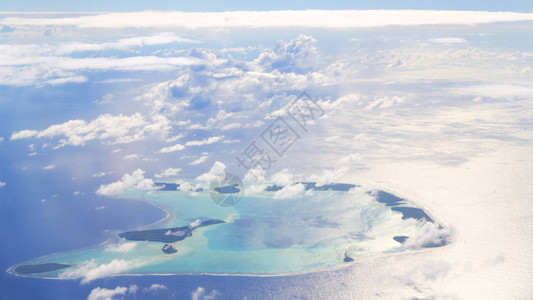 从飞机云层和海洋中可以看到珊瑚礁的景背景图片