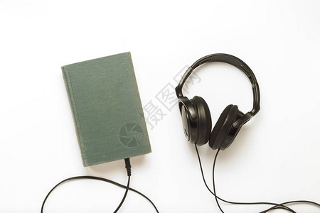 蓝封面书籍和白色背景的黑耳机图片