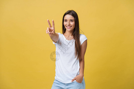 充满欢乐的年轻女人的肖像展示两根手指或胜利姿态图片