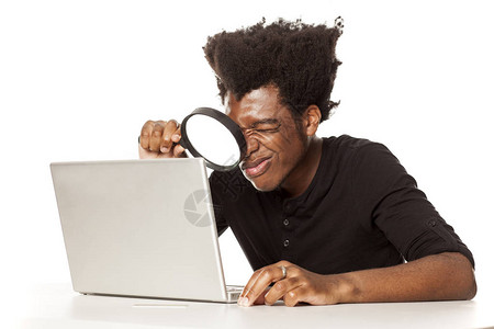年轻非裔美国人看着他的笔记本电脑背景图片