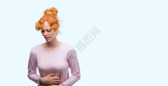 年轻的红发妇女因为消化不良而胃痛图片