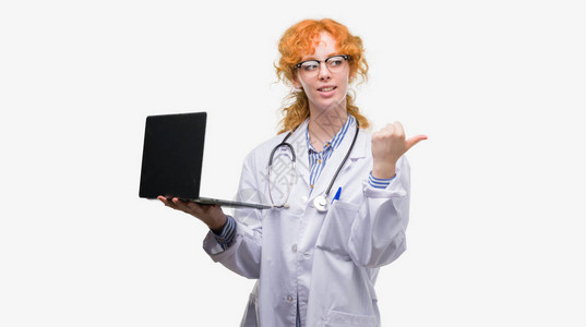 年轻的红发女医生拿着电脑笔记本电脑指着图片