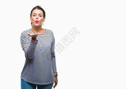 年轻漂亮的女人休闲条纹毛衣在孤立的背景下看着相机用手在空气中吹一个吻图片