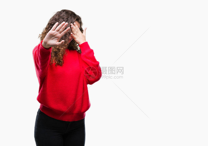 美丽的黑发卷年轻女孩戴着眼镜和冬季毛衣在孤立的背景下用手遮住眼睛图片