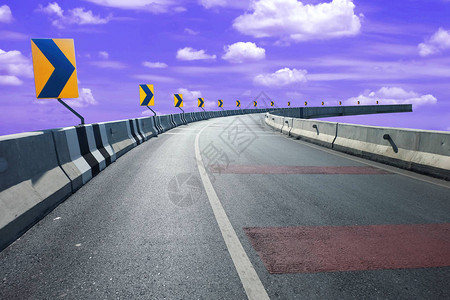 路和蓝天空背景的空洞公路末端的右转标志背景图片