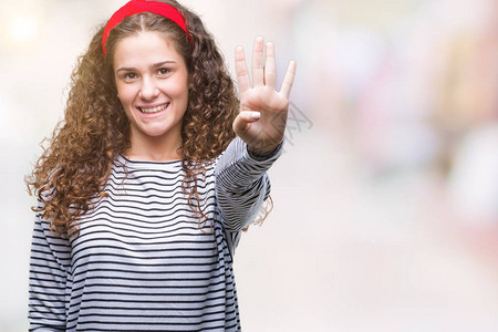 美丽的黑发卷年轻女孩穿着条纹毛衣在孤立的背景下展示并用四号手指向上方图片