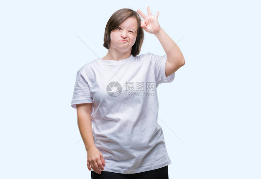 患有唐氏综合症的年轻成年女在孤立的背景下微笑着积极地用手和指做ok的手势图片