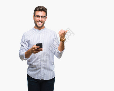 英俊的年轻帅哥用智能手机发短信用孤立的背景指点和大拇指向侧面展示笑图片