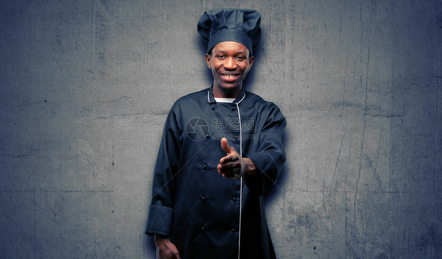 身戴厨帽的年轻黑厨师握起手来欢迎以握手相亲图片