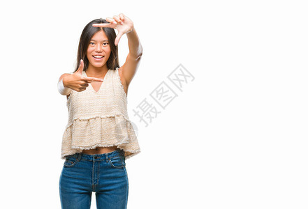 身处孤立背景的年轻亚洲妇女微笑地用手和指搭架图片