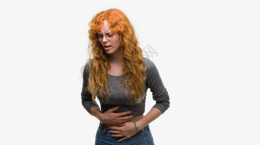 年轻的红发妇女因为消化不良而胃痛图片