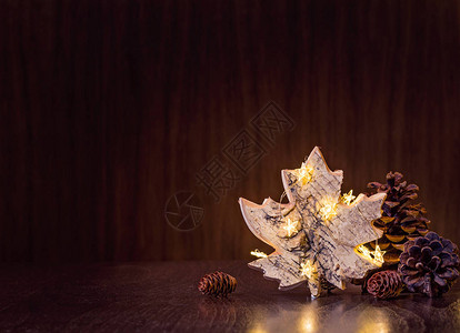 简单自然的圣诞装饰品松果盒和生锈的木叶装饰品包裹在暗木图片