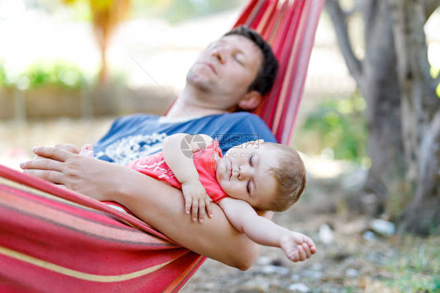 个月大的可爱女婴和她的父亲在户外花园的吊床上安然入睡图片