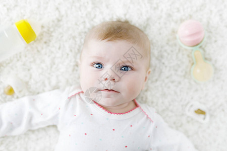 可爱的新生婴儿玩彩色柔和的拨浪鼓玩具哺乳奶瓶和假人图片