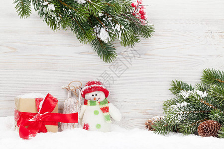 圣诞雪人玩具礼品盒和fir树枝图片