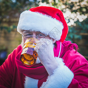 圣诞老人喝玻璃杯里的啤酒庆祝图片