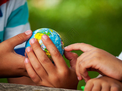 懂礼让一个拥有世界球或地球星的男孩在他的手背景