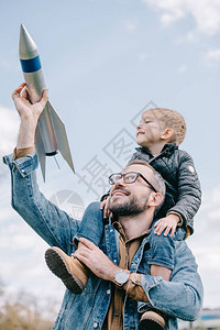 快乐的父亲带着小儿子在脖子上并用模拟图片