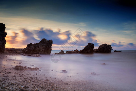 日出时自然石拱门的海景图片