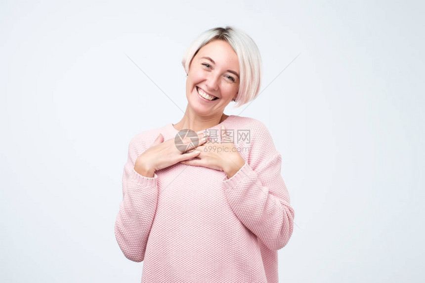 穿着粉红色毛衣满面微笑双手紧贴心胸图片
