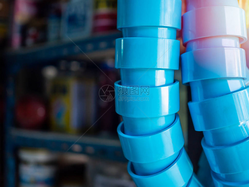堆放在仓库里的管PVC管蓝色管道连接挂在储藏室背景的架子上图片