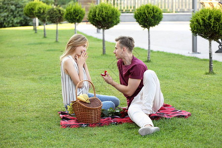 年轻男人在公园的浪漫约会上向女图片