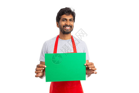 超市或大卖场的印度男员工欢快地展示带有复制文本区域的绿纸图片