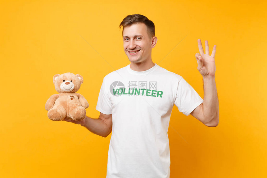 上面写着绿色标题志愿者拿着泰迪熊毛绒玩具图片