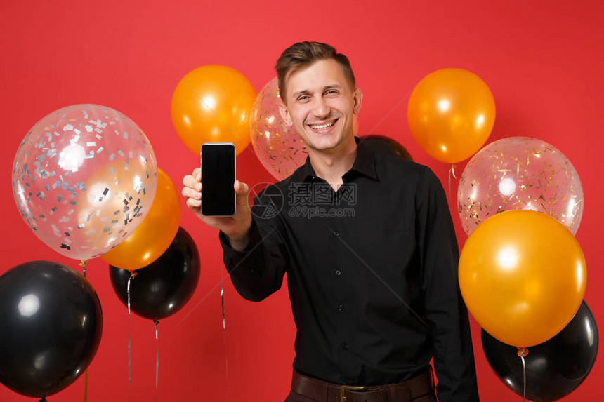 穿着黑色经典衬衫的快乐年轻人拿着手机图片