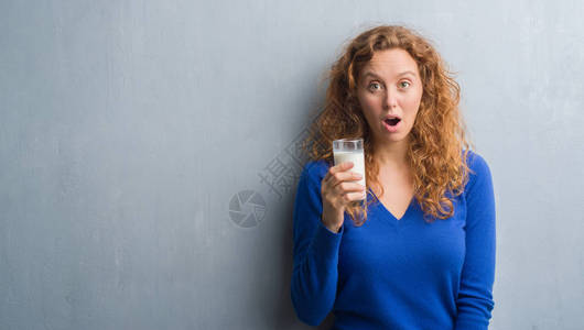 年轻的红发女人喝着牛奶图片