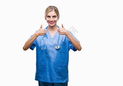 年轻漂亮的金发外科医生护士女人在孤立的背景成功标志上用手做积极的手势背景图片