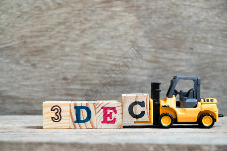 玩具叉车在木本背景上为填全字3Dec日历期3的概图片