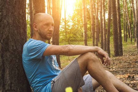 男人坐在树林里图片