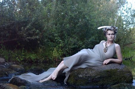 身着灰色丝绸礼服羽毛长袍和海蜗牛项链森林女神图片
