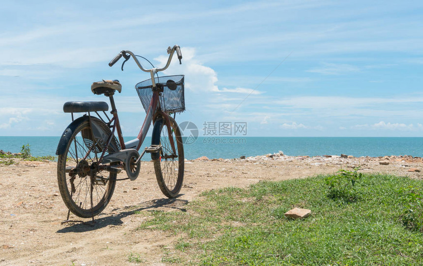 在海滩和蓝天和海或盐水的红色自行车在岩石或丘或桩上骑自行车在放松心情的图片