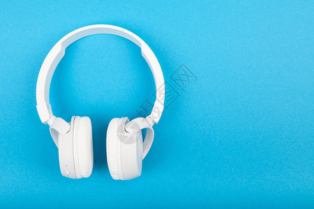 蓝背景的无线白耳机音乐概念图片
