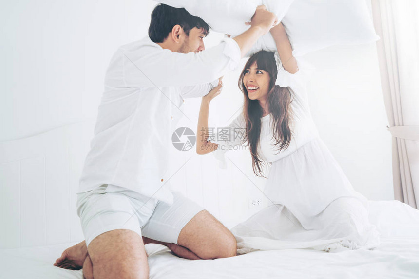 夫妻在卧室里做枕头搏斗幸福的家庭生图片
