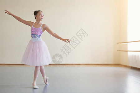 芭蕾服装的小芭蕾舞演员和足尖鞋在房间里跳图片