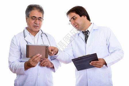 年轻和年长的波斯人医生使用数码平板电脑图片