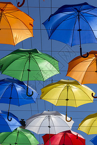翱翔的彩色雨伞映衬着蓝天图片