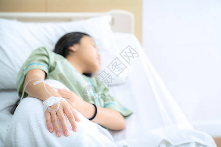 亚洲女病人睡眠盐溶液线在医院的床上图片