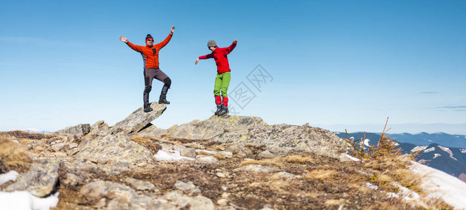 两名登山者爬上了山顶男人们在岩石上保持平衡在山上远足的朋友登图片