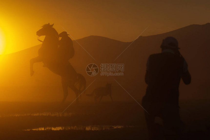 一名牛仔用脚骑马在日落时双脚停留图片