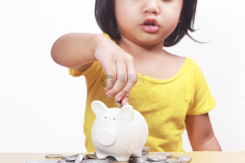 商业经济金融投资概念可爱的小亚洲女婴在她的小猪银行存图片